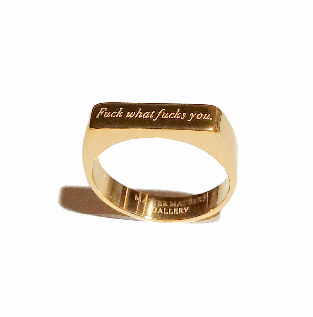 Gold ring with engraved text on a white background
