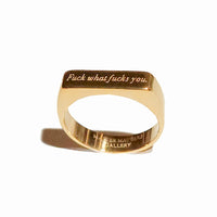 Gold ring with engraved text on a white background