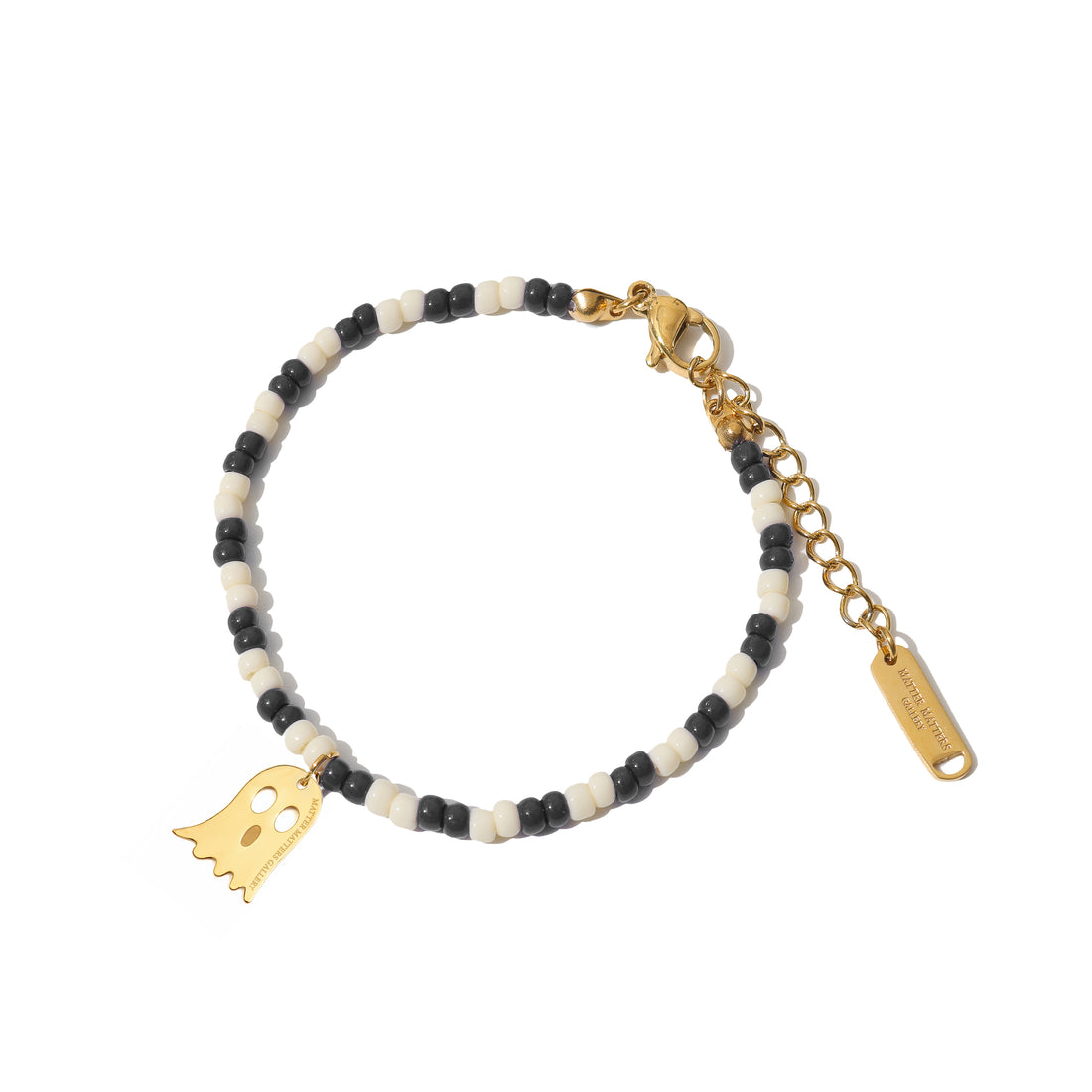 ghost pendant Bracelet with black, white, and gold beads on a white background