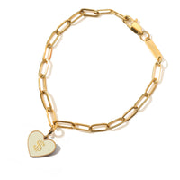 Gold chain bracelet with a heart-shaped $ tag on a white background