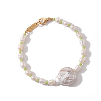 A delicate beaded bracelet featuring irregular white baroque pearls, small light green beads, and a large textured white shell centerpiece, finished with a gold-tone lobster clasp. The brand name 'SARABAR' is engraved on the clasp.