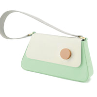 A light mint green and white flap shoulder bag with a wide strap and a leather shoulder strap, featuring a matt gold D ring and resin stud.