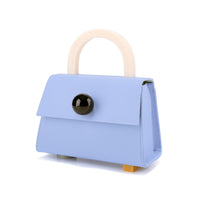 A retro boxy light blue cow leather satchel bag with a resin handle and studs, featuring a detachable shoulder strap, a canvas lining, and an embossed logo on the back patch pocket.