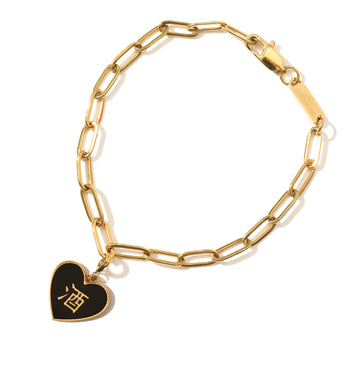A gold-plated gold stainless steel bracelet with a black and pink heart-shaped 酒pendant attached to a chain.