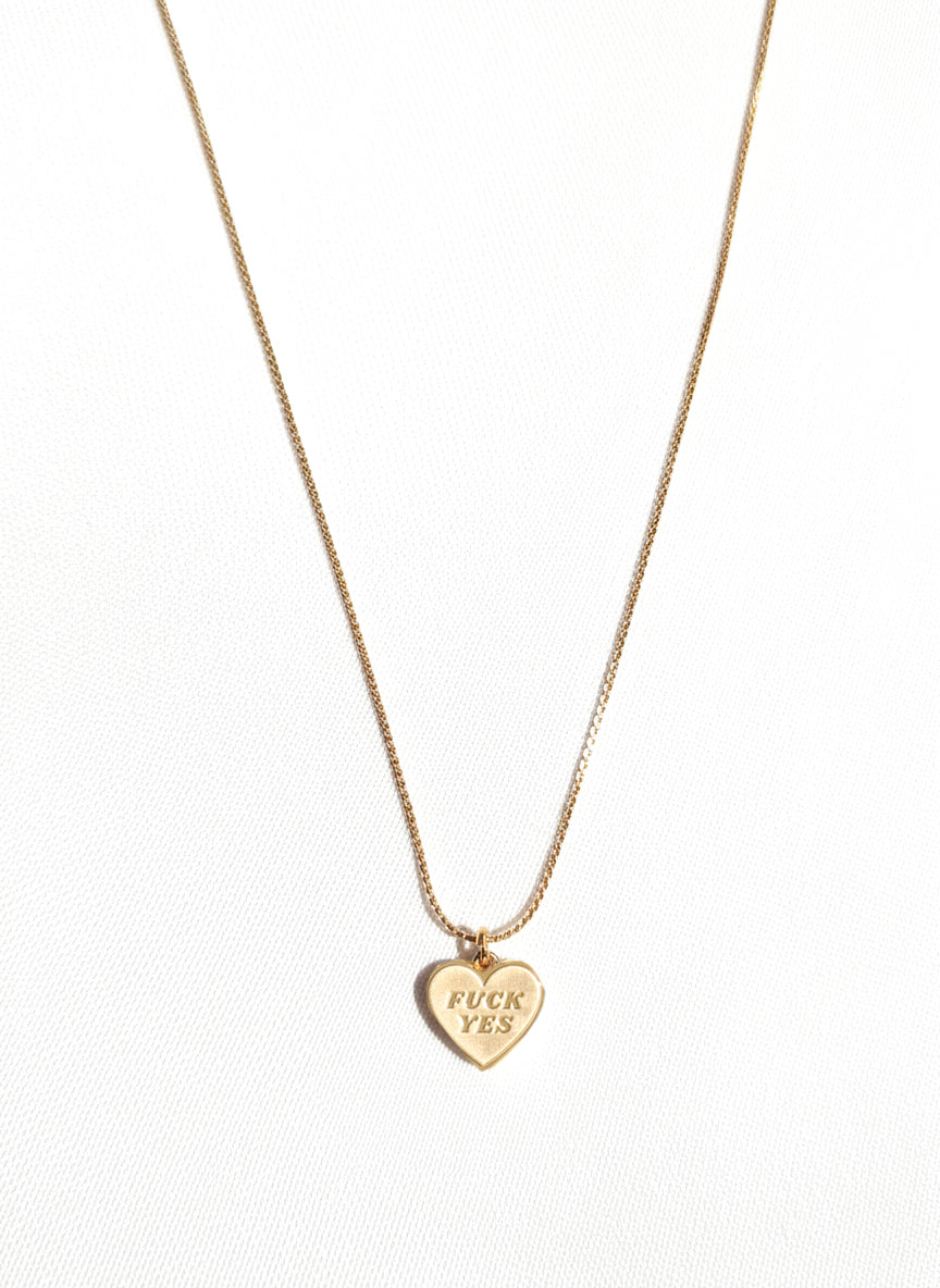 Gold necklace with a heart-shaped pendant on a white background
