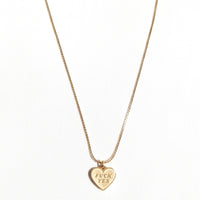 Gold necklace with a heart-shaped pendant on a white background